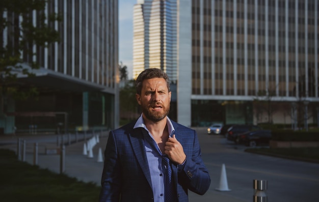 Angry businessman in suit after work in office screaming\
face