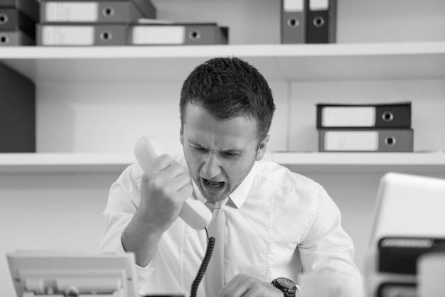 Photo angry businessman talking on the phone