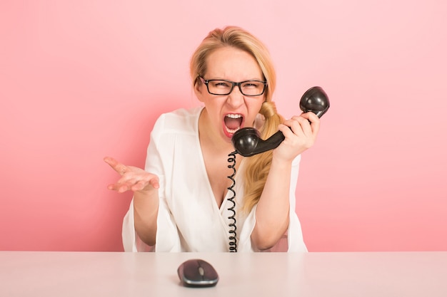 Angry businesswoman with vintage telephone