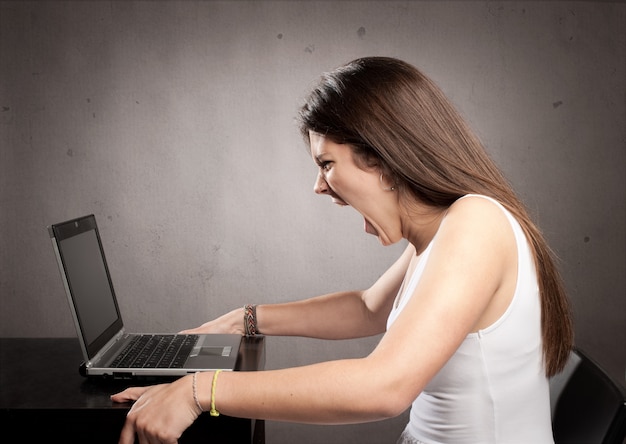 Angry businesswoman working with a laptop