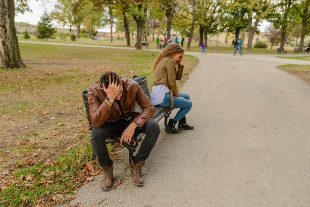 写真 公園のベンチに座っている怒ったカップル