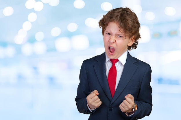 Angry curly boy in a formal suit