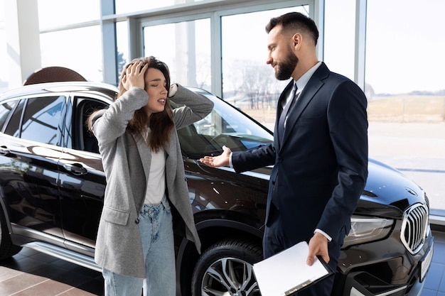 Angry customer at car dealership talking to car dealer car insurance concept