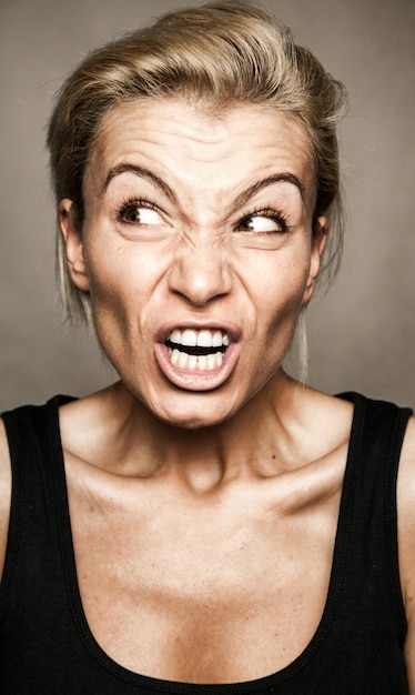 Photo angry expression on the young woman's face