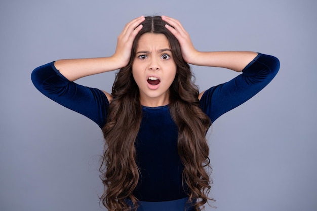 Angry face upset emotions of teenager girl Children studio portrait on yellow background Childhood lifestyle concept Cute teenage girl face close up