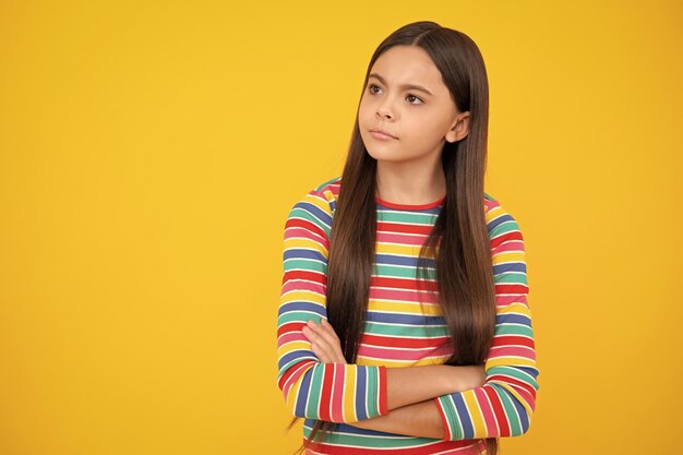 Angry face upset emotions of teenager girl portrait of caucasian teen girl with arms folded isolated on yellow background cute teenager child