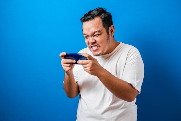 Angry Fat Asian Guy Playing Games on Tablet Smart Phone