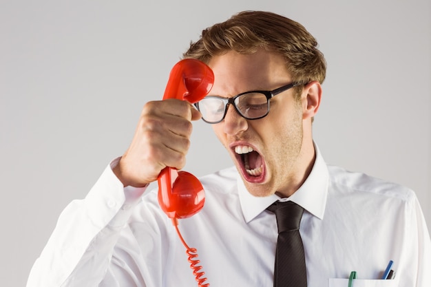 Photo angry geeky businessman holding telephone