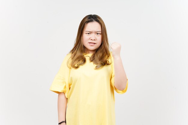 白い背景で隔離の黄色のTシャツを着ている美しいアジアの女性の怒っているジェスチャー