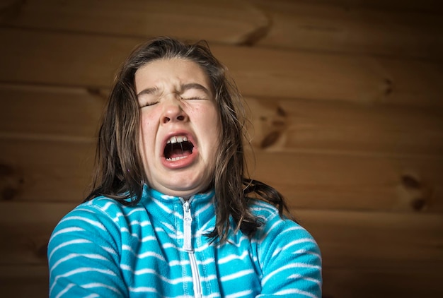 angry girl shouting against wooden wall