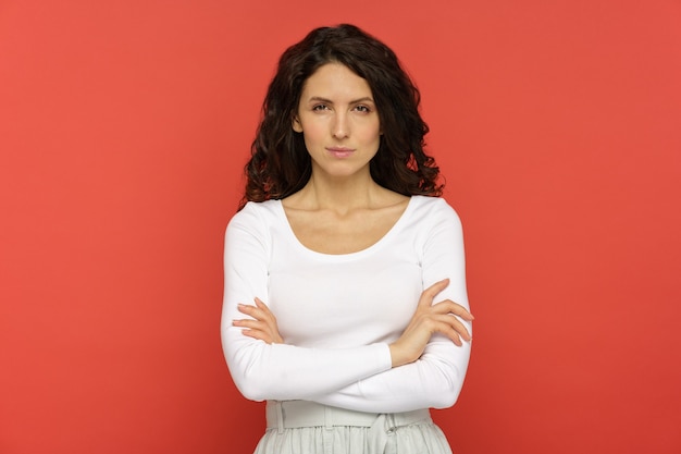 Angry grumpy female hold hands folded at studio wall dissatisfied woman displeased offended face