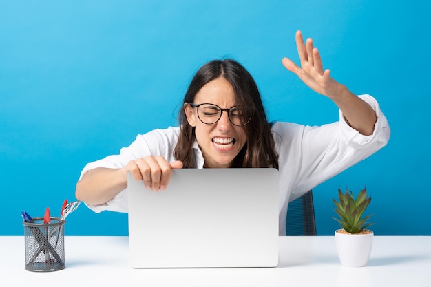 Angry hispanic woman holding laptop