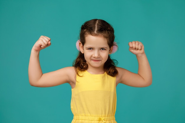 Angry little child girl in dress raising fist