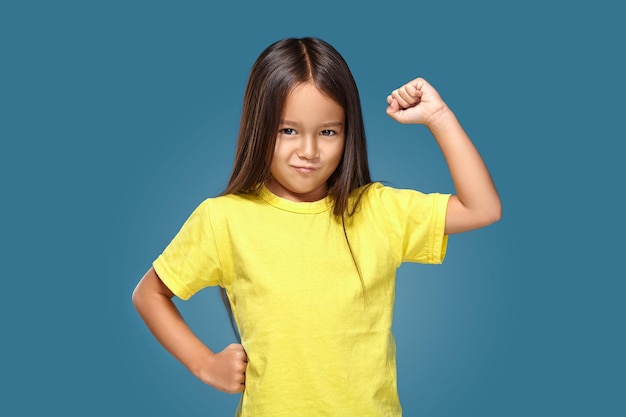 Photo angry little kid showing frustration and disagreement on blue background