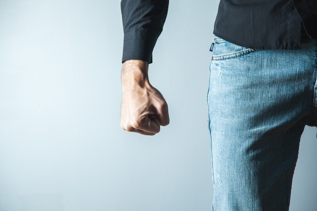 Angry man fist on gray wall