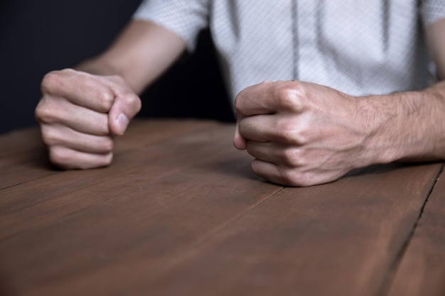 Angry man fists on table