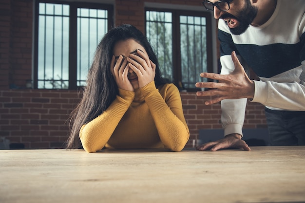 Uomo arrabbiato e donna triste sul tavolo