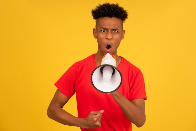 Angry man screaming through a megaphone to raise his voice up and protest something.