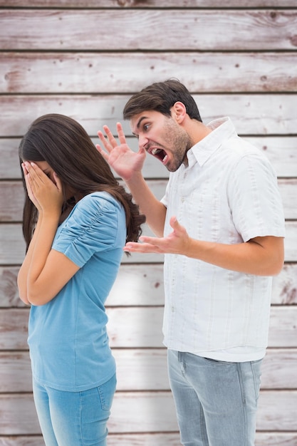 Angry man shouting at girlfriend against wooden planks