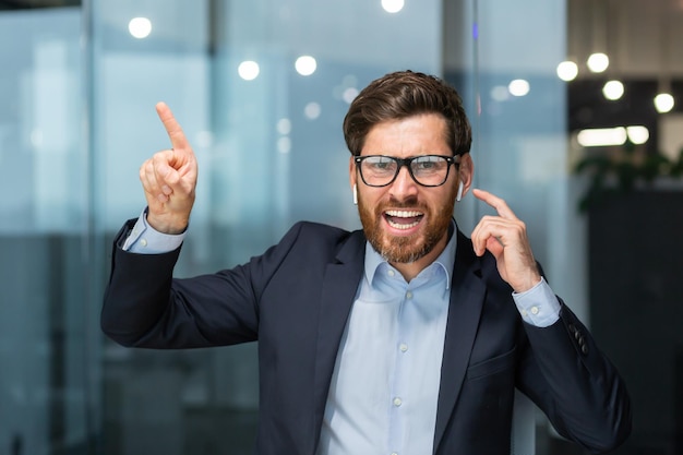 Angry mature director boss arguing and shouting at camera senior man in office at work