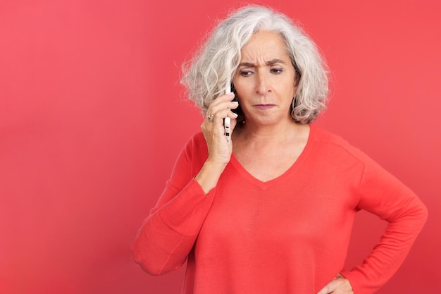 Angry mature woman talking on the mobile phone