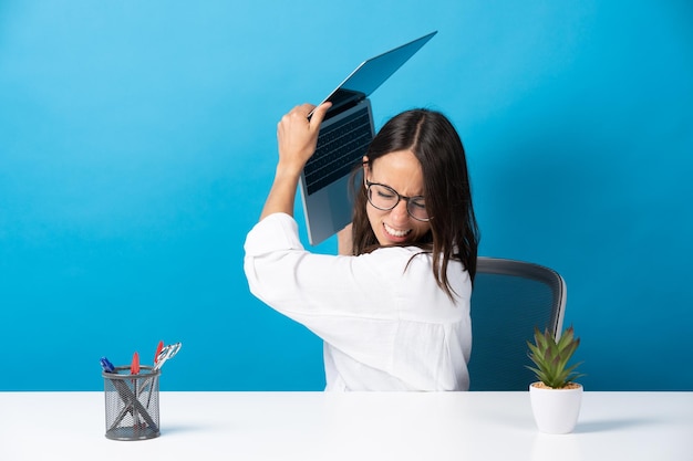 Angry office worker throwing laptop