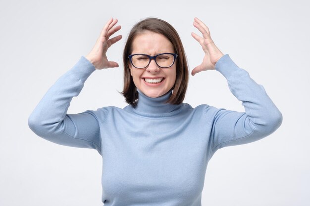 Photo angry scared young woman screaming holding hands near face arguing with her husband