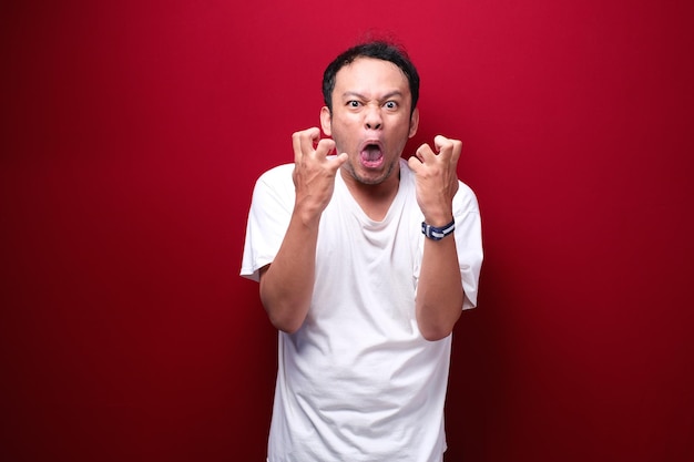 Angry and stress young Asian man raising his arm up
