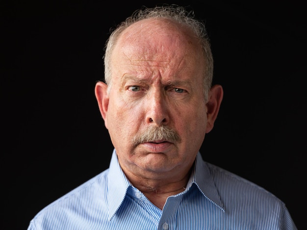 Angry and stressed grey haired senior man with mustache