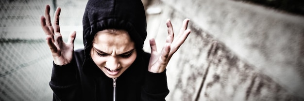 Angry teenage girl standing at school campus