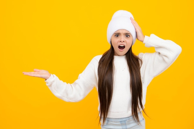 怒っている 10 代の少女の動揺と不幸な否定的な感情 黄色の背景に分離された広告広告を指しているコピー スペースで示す 10 代の子供の女の子の肖像画 コピー スペースのモックアップ