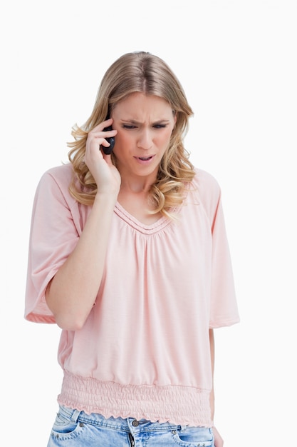 An angry woman is talking on her mobile phone 