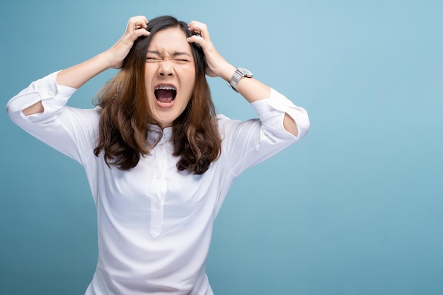 写真 怒った女性が青い背景で叫んでいる