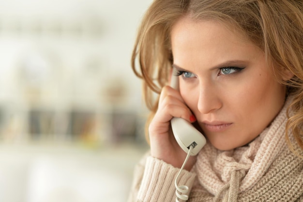 Photo angry woman talking on the phone, blurred background