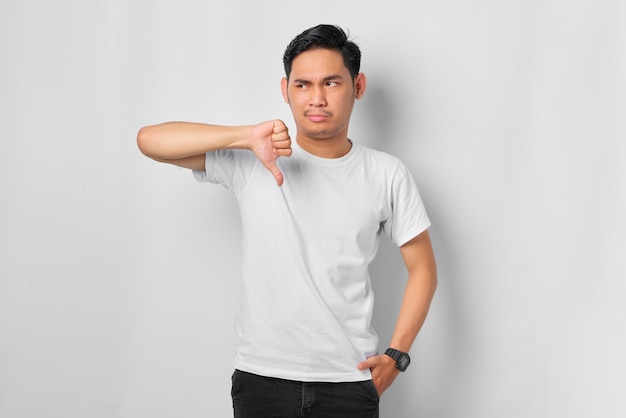 Angry young Asian man showing rejection and negative with thumbs down gesture isolated on white background