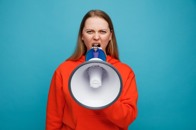 Angry young blonde woman talking by speaker 