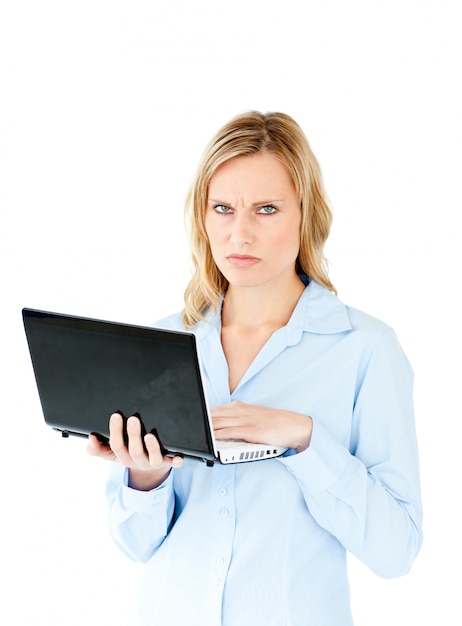 Angry young businesswoman holding a laptop