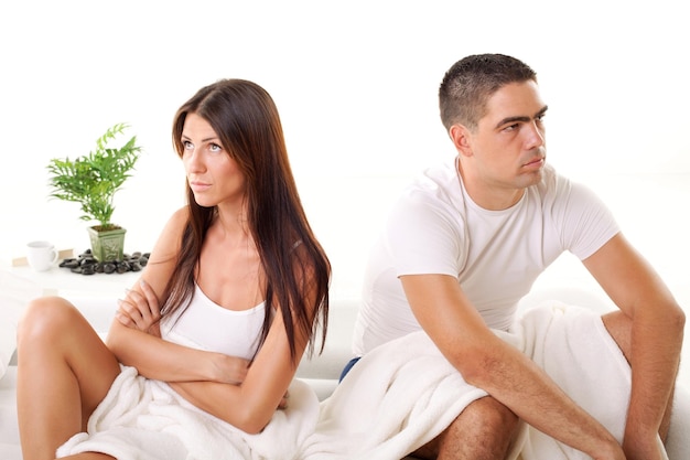 Photo angry young couple sitting on the bed because of  relationship difficulties