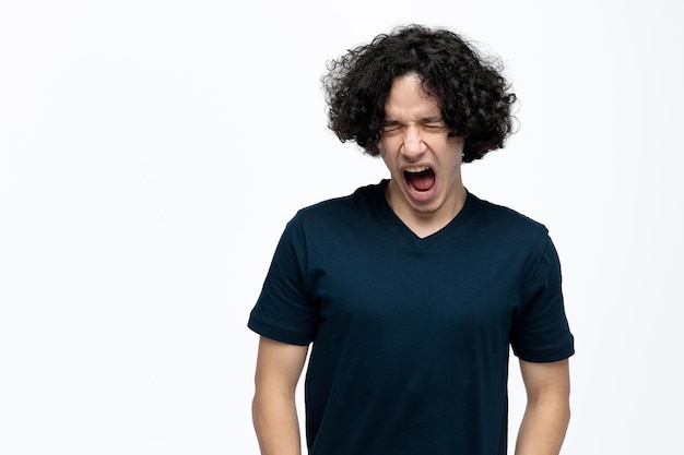 Angry young handsome man screaming with closed eyes isolated on white background