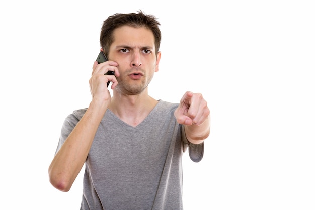 写真 携帯電話で話しているときに指を指している怒っている若い男