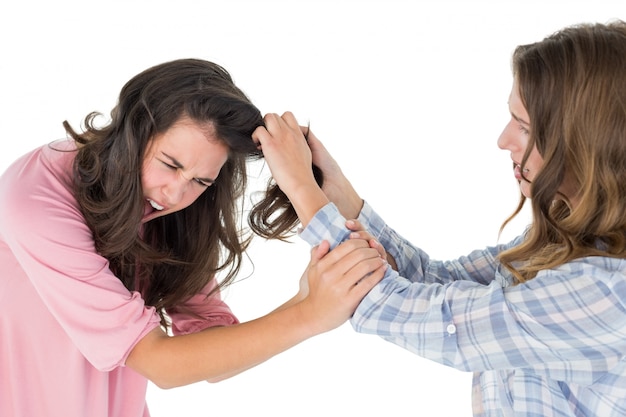 Photo angry young woman pulling females hair in a fight