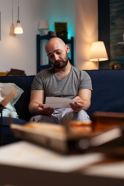 Angstige gefrustreerde depressieve jongeman die brief leest