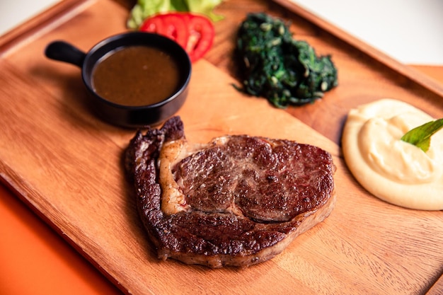 写真 アングス・ビーフ・リベイ・ステーキ (angus beef ribeye steak) スパナッチジャガイモ黒胡<unk>ソース