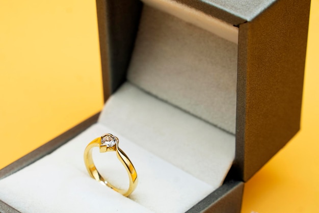 Anillo de diamantes en caja de regalo de joyeria sobre fondo amarillo