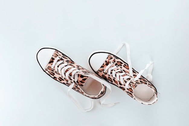 Sneaker bianche alla moda con stampa animalier su sfondo grigio chiaro