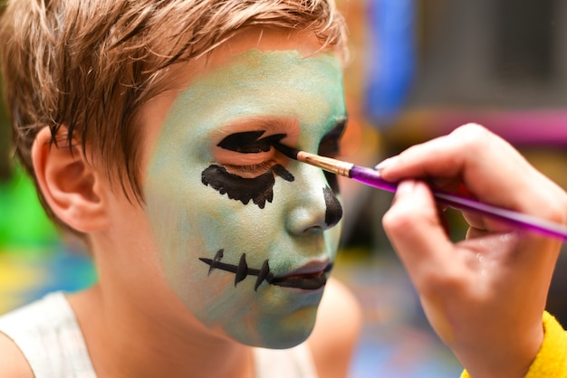 Photo the animator paints the face of the child