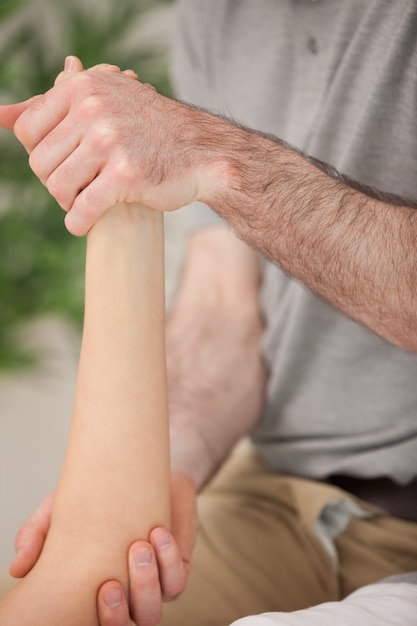 Photo ankle and elbow of a patient being manipulated in a medical room