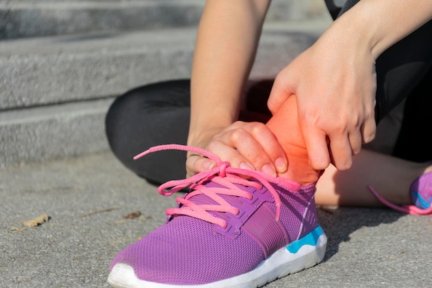 Photo ankle pain caused by exercise women who are sitting and use the handle on the ankle from the pain from being able to run until an ankle flip