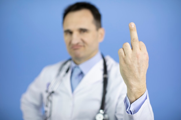 Annoyed doctor showing middle finger, impolite and rude fuck off expression