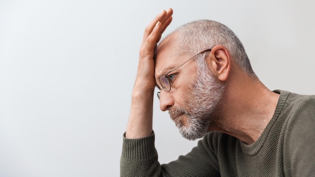 Annoyed elderly man close up in profile